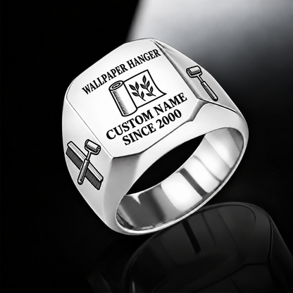 Silver-finish Wallpaper Hanger Signature Crest signet ring with partly unfurled leaf-pattern wallpaper, wallpaper brush and seam-roller shoulder engraving, and illustrated CUSTOM NAME and SINCE 2000 text