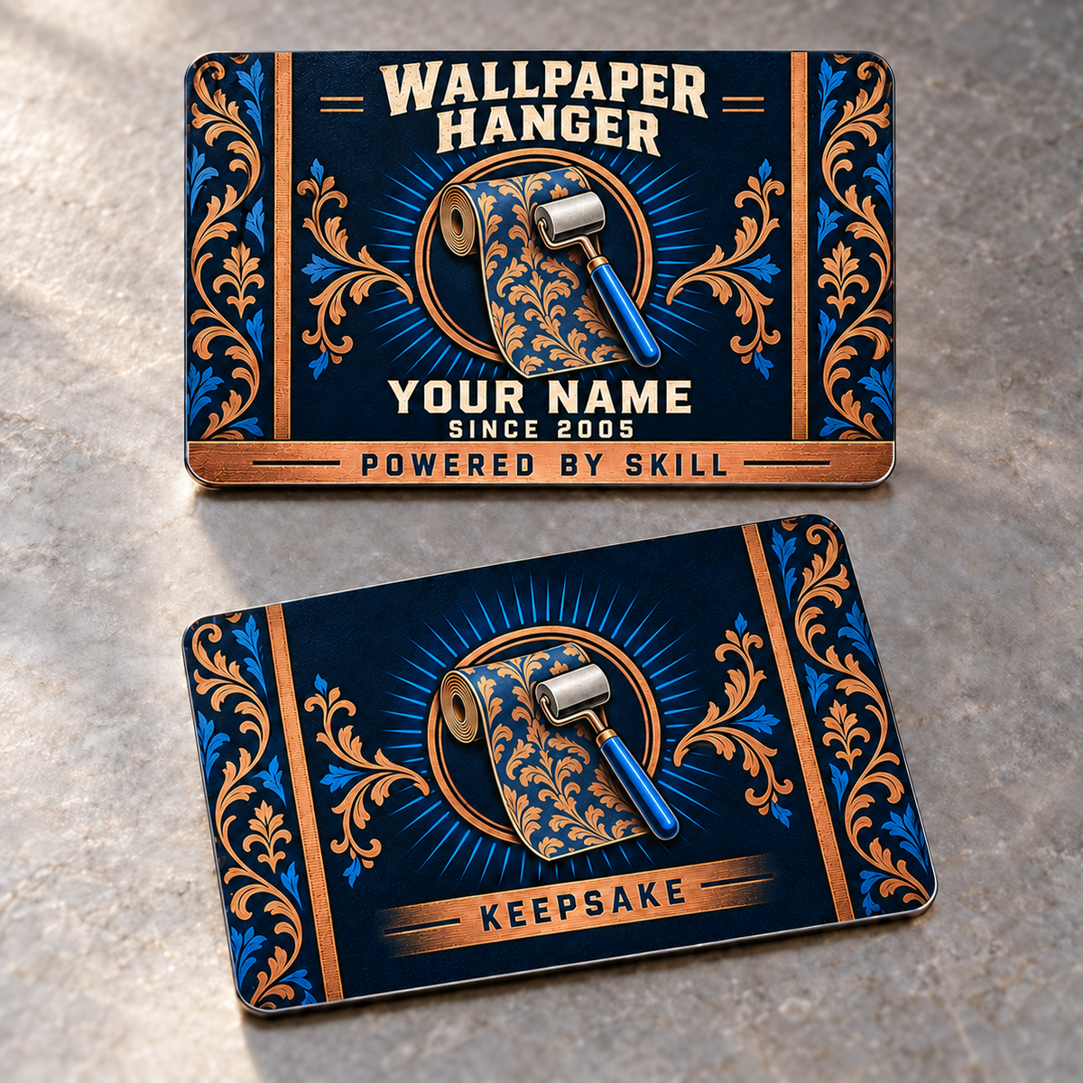 Front and reverse of the thin rounded Wallpaper Hanger Toolmark Heritage aluminum wallet card, with patterned wallpaper roll and seam roller medallions, blue rays and copper damask borders. The front reads WALLPAPER HANGER, YOUR NAME and POWERED BY SKILL; the reverse reads KEEPSAKE.