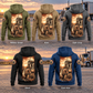 Five separated back views of the Trucker Daily Commitment Portrait Vintage Hoodie in Military Green, Kaki, Dark Gray, Black and Dark Blue, each with a tall sepia kneeling-trucker and parked-truck panel and small sleeve motifs, against a stationary unbranded truck and open-road landscape.