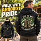 Black Arborist Walk the Walk Badge Vintage Hoodie worn in a leafy tree-care yard, showing its large boots-and-tree back print and a smaller front view with CUSTOM NAME and SINCE 2000.