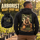 Black Arborist Ready Every Day Portrait Vintage Hoodie on an off-duty adult at a tree nursery, showing kneeling-arborist back artwork and a smaller front view with CUSTOM NAME and SINCE 2000.