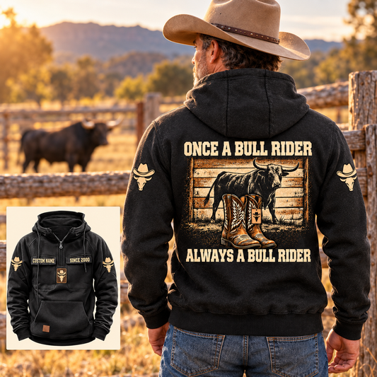 Adult cowboy wearing the Black Once and Always Bull Rider hoodie at a sunlit ranch corral, with large bull-and-boots back artwork and a smaller front-view inset.