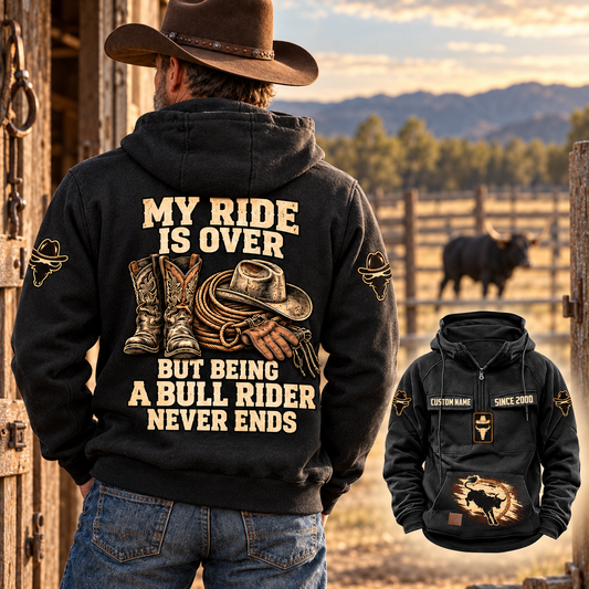Adult cowboy wearing the Black Bull Rider Never Ends Vintage Hoodie beside a stable, showing its western back artwork and a smaller front view.