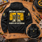 Black Electrician Once and Always Vintage Hoodie laid back-up on an electrician workbench with boots and circuit artwork, unplugged cable reel and a smaller front view showing CUSTOM NAME and SINCE 2000.