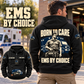 Black EMS By Choice Vintage Hoodie modeled from the back outside an ambulance station, with cream and navy BORN TO CARE artwork and a smaller front view.