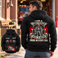 Black Firefighter Heritage Crest Vintage Hoodie shown from the back on an off-duty model outside a brick fire station, with a smaller front-view inset.