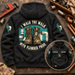 Black Plumber Walk the Walk Badge Vintage Hoodie on a plumbing workbench, with a large boot-and-pipework back design and smaller front view showing CUSTOM NAME and SINCE 2000.