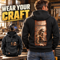 Black Welder Workday Portrait Vintage Hoodie worn from the back in a quiet workshop, showing the distressed kneeling-welder illustration, with a smaller front view and WEAR YOUR CRAFT headline.