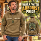 Arborist Walk the Walk Badge Vintage Hoodie in Kaki, front left back inset composition with faithful front and back artwork in a calm arborist equipment shed beside leafy trees.