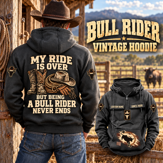 Bull Rider Never Ends Vintage Hoodie in Dark Gray, back left front cutout composition with faithful front and back artwork in a weathered timber rodeo stable, outdoors.