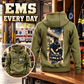 EMS Workday Portrait Vintage Hoodie in Military Green, back right front inset composition with faithful front and back artwork in a calm station entrance with a parked ambulance softly out of focus.
