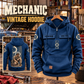 Mechanic Daily Commitment Portrait Vintage Hoodie in Dark Blue, front right back card composition with faithful front and back artwork in a tidy auto workshop with a vintage vehicle blurred behind.