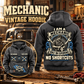 Mechanic Heritage Crest Vintage Hoodie in Dark Gray, back right front inset composition with faithful front and back artwork in a tidy auto workshop with a vintage vehicle blurred behind.