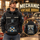 Mechanic Skills and Pride Vintage Hoodie in Black, front left back inset composition with faithful front and back artwork in a tidy auto workshop with a vintage vehicle blurred behind.