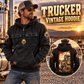 Trucker Daily Commitment Portrait Vintage Hoodie in Black, front left back inset composition with faithful front and back artwork in a quiet roadside truck stop with a parked tractor cab blurred behind.