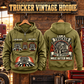 Trucker Heritage Crest Vintage Hoodie in Military Green, paired front back composition with faithful front and back artwork in a quiet roadside truck stop with a parked tractor cab blurred behind.