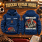 Trucker By Choice Vintage Hoodie in Dark Blue, paired front back composition with faithful front and back artwork in a quiet roadside truck stop with a parked tractor cab blurred behind.