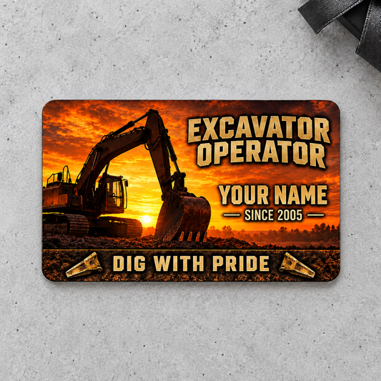 Front of the Sunset Workday Excavator Operator aluminum wallet card on a light gray concrete surface.