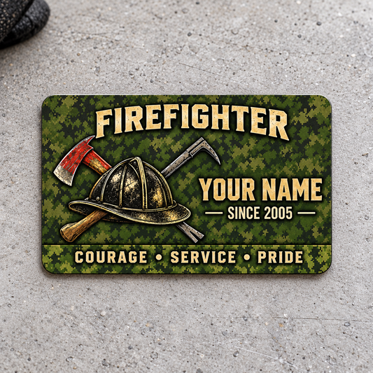 Front of olive camouflage Firefighter aluminum wallet card with helmet and crossed tools on light gray concrete.