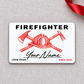 Front of white Firefighter aluminum wallet card with red helmet line art and script name on gray fabric.