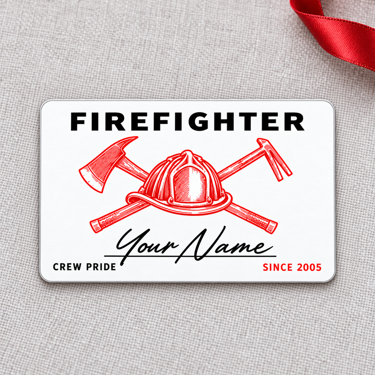Front of white Firefighter aluminum wallet card with red helmet line art and script name on gray fabric.