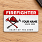 Front of red-header Firefighter aluminum wallet card with helmet and crossed tools on pale oak.
