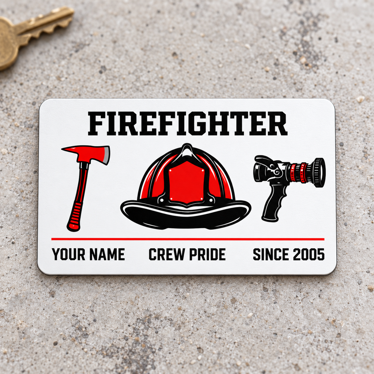 Front of white Firefighter aluminum wallet card with red and black axe, helmet and nozzle on pale concrete.