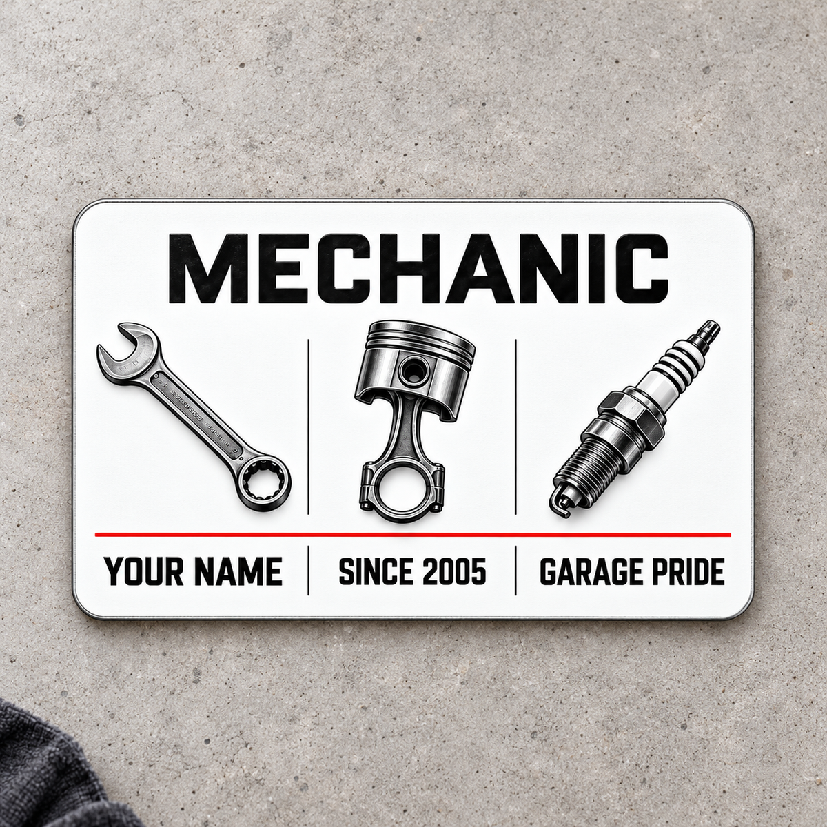 Front of Mechanic Minimal Tool Grid aluminum wallet card on pale gray concrete.