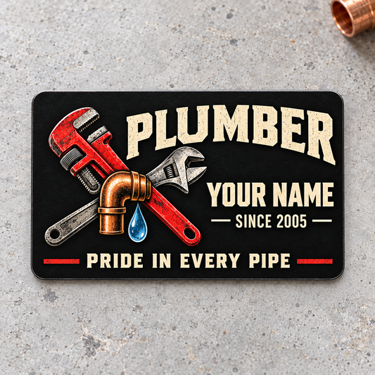 Plumber Midnight Pride aluminum wallet card, front design on light gray concrete.