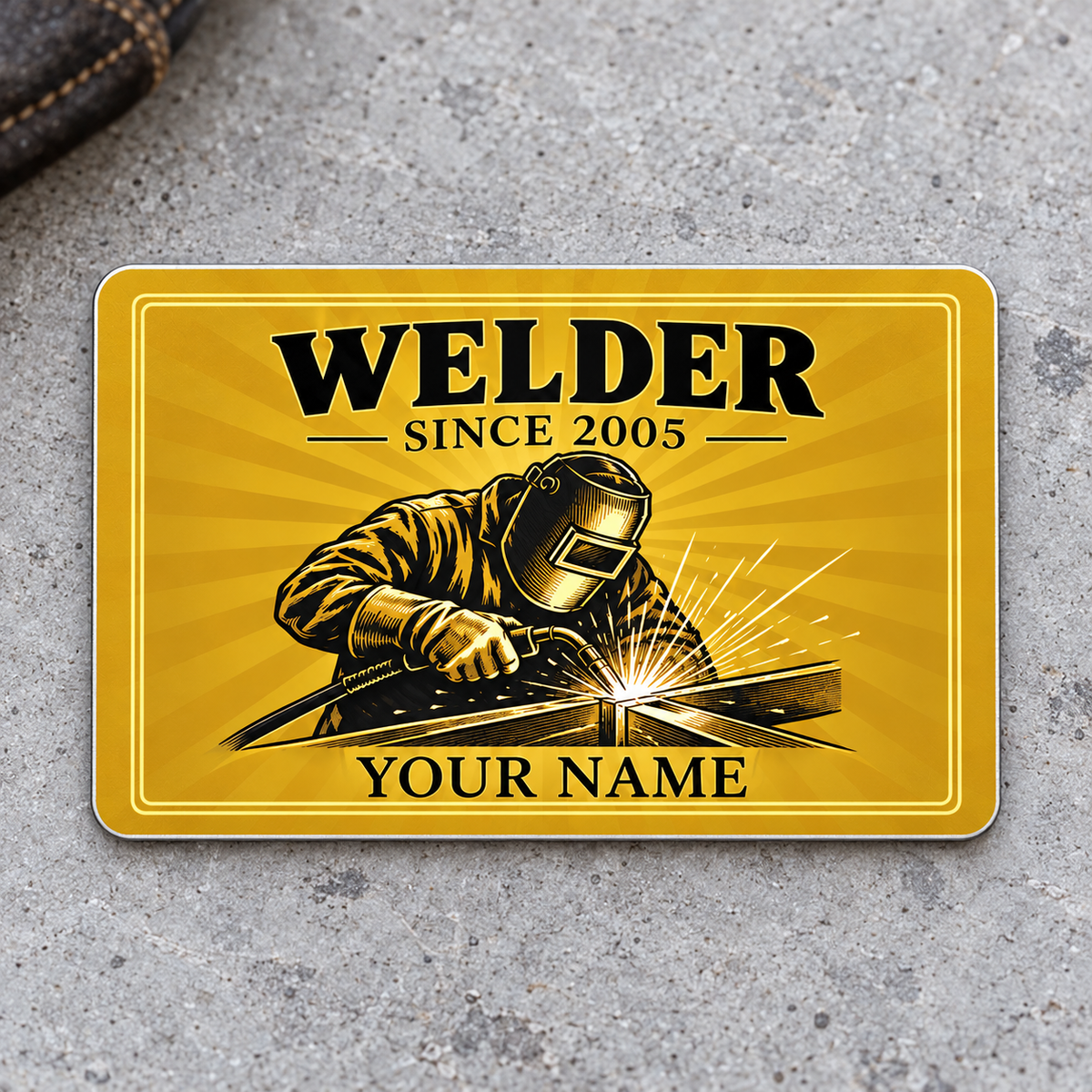 Welder Golden Milestone aluminum wallet card front on gray concrete