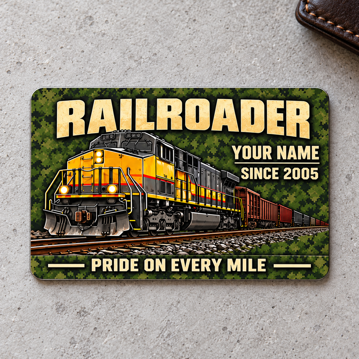 Railroader Rugged Field aluminum wallet card, front face on pale gray concrete.