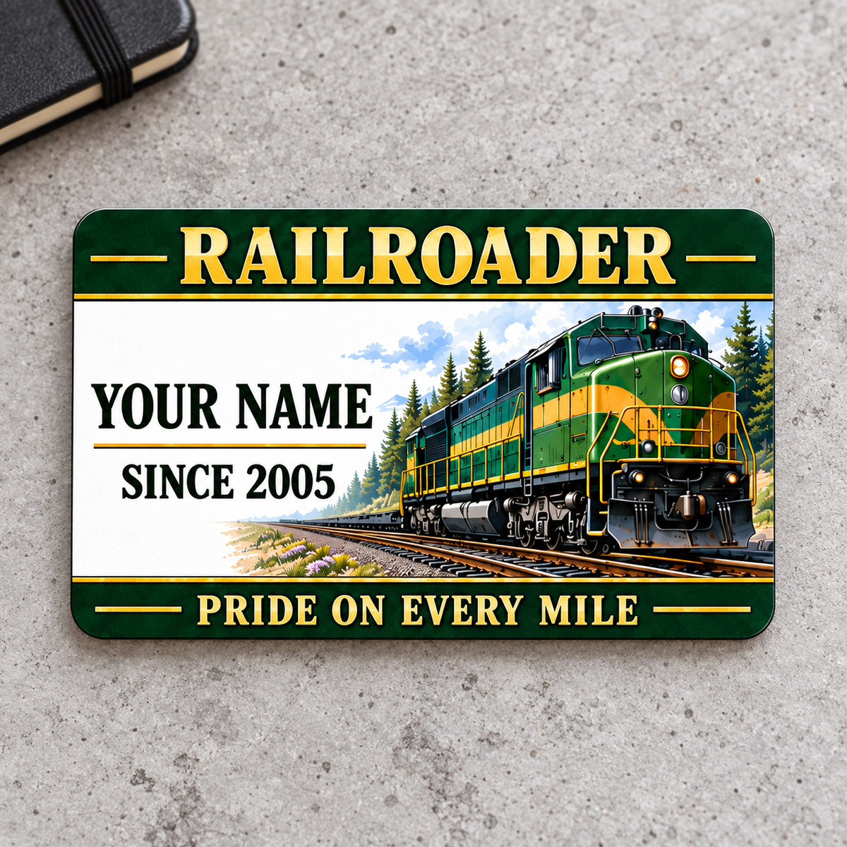 Railroader Heritage Band aluminum wallet card front on gray concrete, with green-and-gold locomotive artwork.