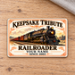 Railroader Ivory Heritage aluminum wallet card front on pale oak, with a steam locomotive and ornate ivory-and-gold design.