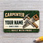 Front of the Carpenter Heritage Band aluminum wallet card on light gray wood.