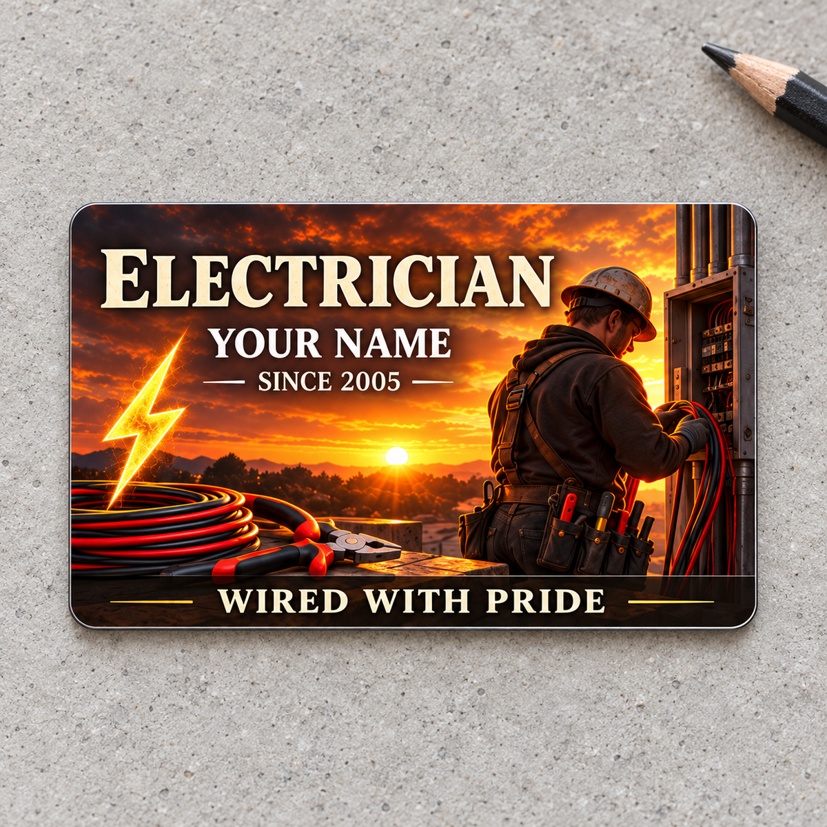 Electrician sunset artwork aluminum wallet card, front view on warm gray concrete