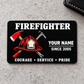 Black firefighter aluminum wallet card with red helmet and crossed tools, centered on pale gray concrete.