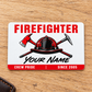 White firefighter aluminum wallet card with red helmet, crossed tools and crew-pride lettering on light oak.