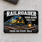 Railroader Midnight Pride aluminum wallet card front, centered on pale gray concrete.