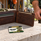 Arborist wallet card in an arborist tree-care rest area with an adult man and leather wallet.