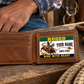 Bull Riding/Rodeo Green Band aluminum wallet card resting within one panel of an open tan wallet