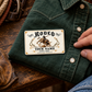 Bull Riding/Rodeo Ivory Heritage aluminum wallet card on a folded green Western shirt beside an adult hand