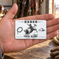 Bull Riding/Rodeo Minimal Tool Grid aluminum wallet card resting on an adult open palm in a tack room