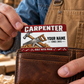 The printed front of the Carpenter Red Header Trade Pride aluminum wallet card shown in an occupational lifestyle setting with an adult worker.