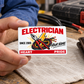 Electrician Signature Classic aluminum wallet card held over pale linen beside a worn wallet