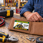 Electrician Green Band wallet card resting on one panel of an open tan leather wallet