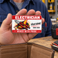 Electrician Red Header aluminum wallet card resting on an open palm above a tan bifold wallet