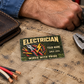 Electrician Rugged Field aluminum wallet card on canvas beside a worn wallet, pliers and disconnected cable