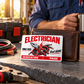 Electrician Signature Modern wallet card leaning against a brown wallet on a slate workbench