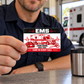 EMS Red Monochrome wallet card held at a station break counter by an adult worker.