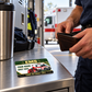 EMS Heritage Band wallet card lying flat on a station shelf while an adult worker opens a leather wallet.